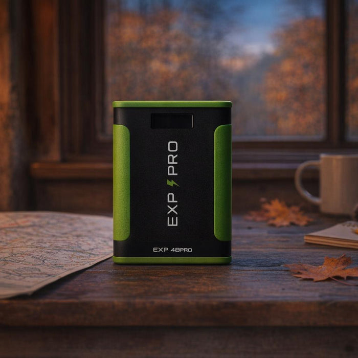 An EXP48PRO APEX CPAP battery on a cabin table with a road map, notebook and fall leaves at dusk.